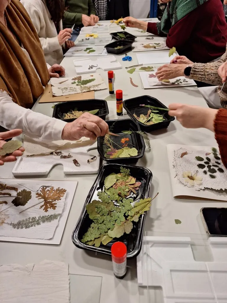 Participantes trabajan con hojas y material botánico durante un taller